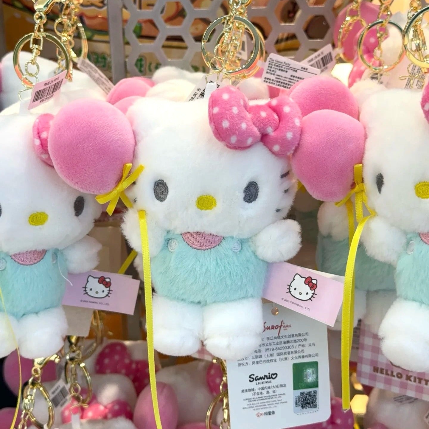 Hello Kitty plush keychains with tags on a display stand